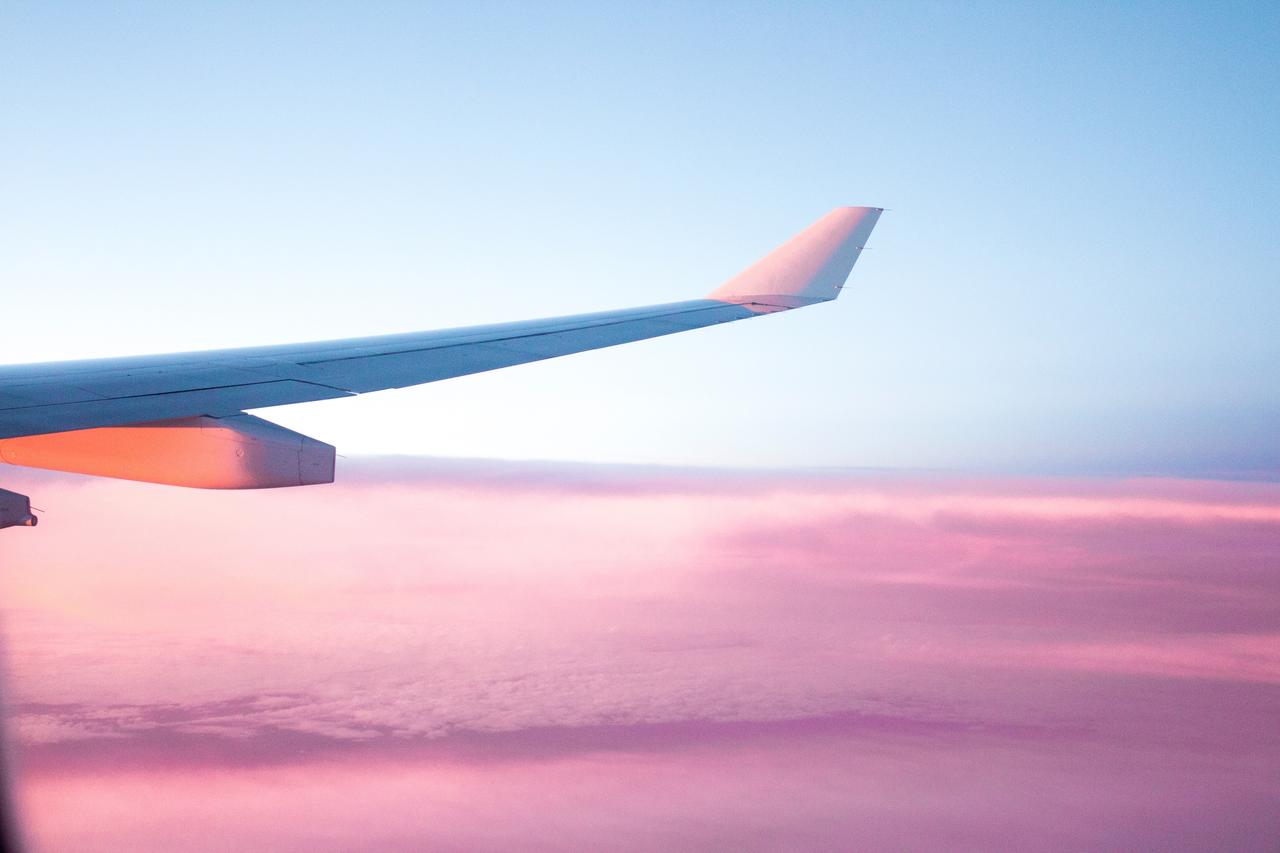 Airplane wing with pink beautiful sky